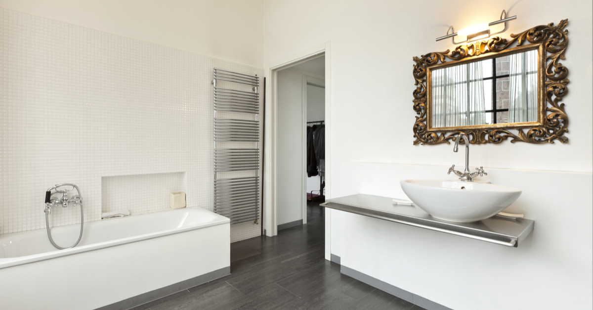 Baño en blanco con detalle espejo en dorado