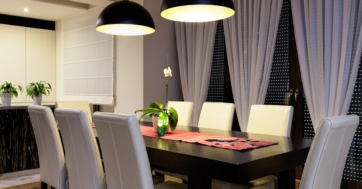 Mesa comedor en color negro con sillas en blanco