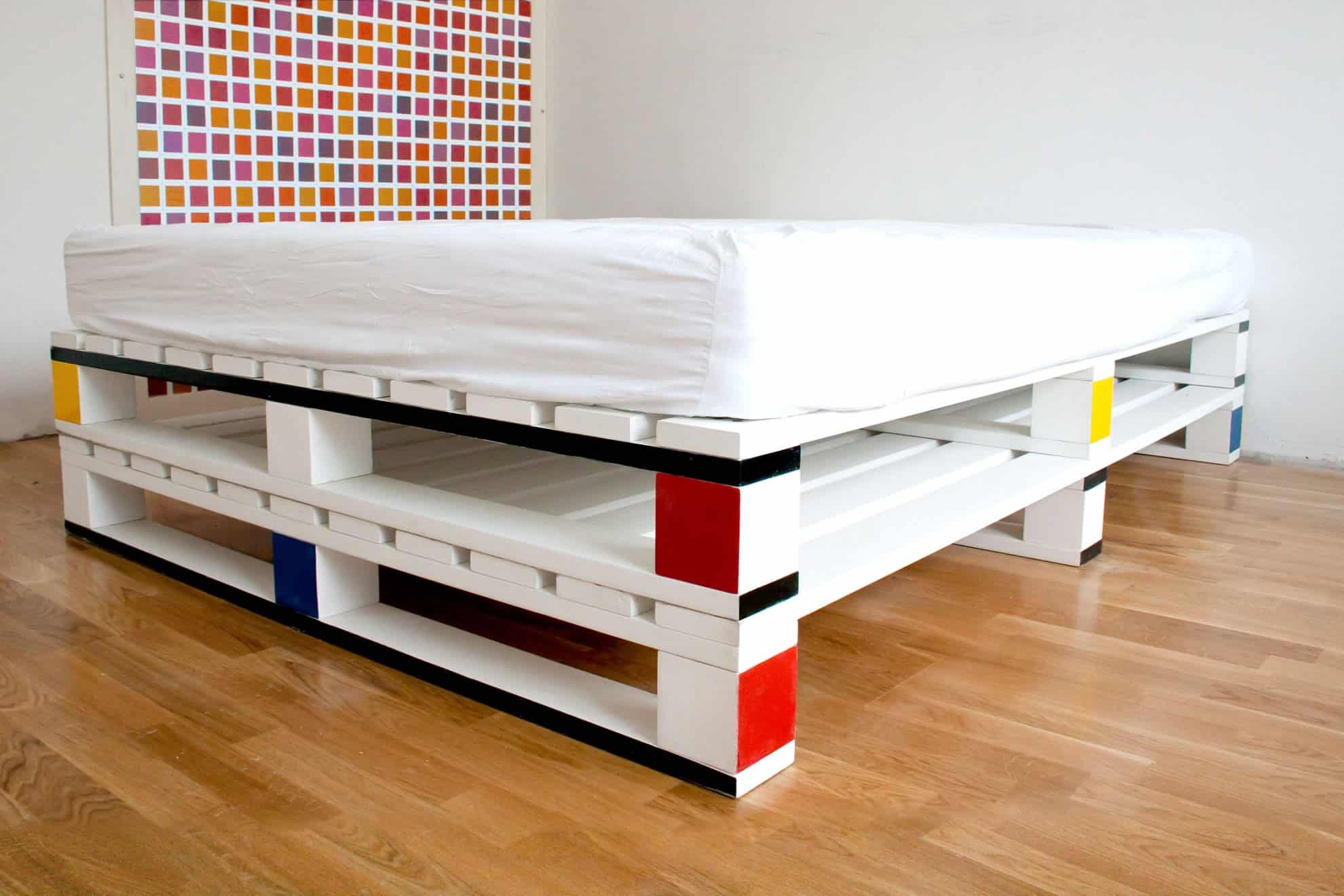 Cama con palés pintados de doble altura