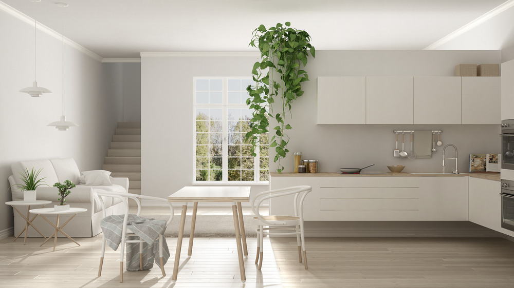 Nordic style kitchen with white tones, wood, plants, natural lighting.