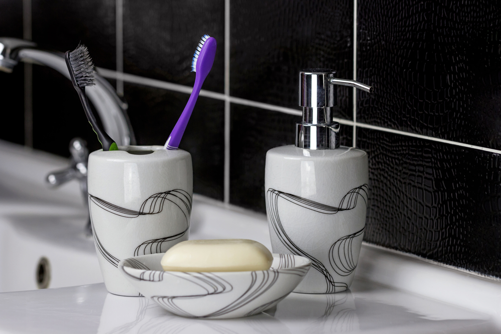 Conjunto para el baño de jabonera con cepillo de dientes y su correspondiente vaso.
