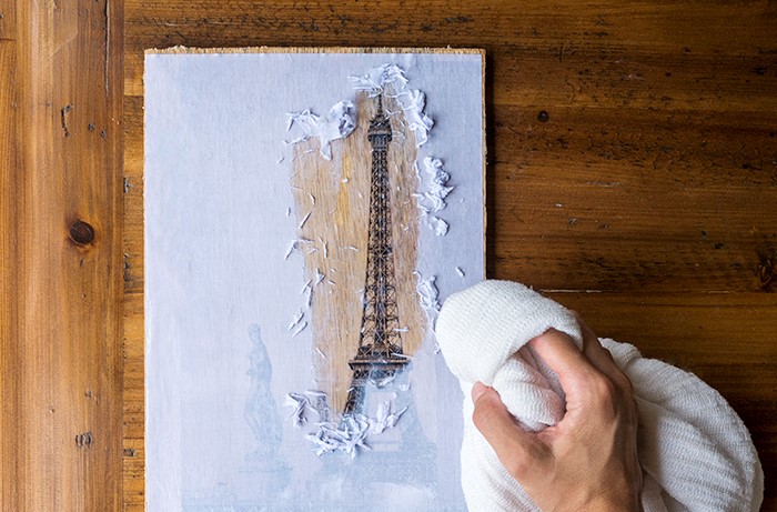 Retirar el papel de la madera.