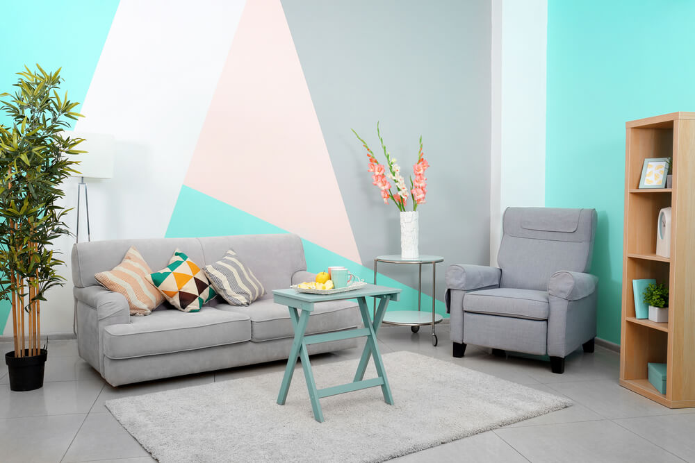 A living room with walls painted in turquoise, white, pale pink, and light gray.