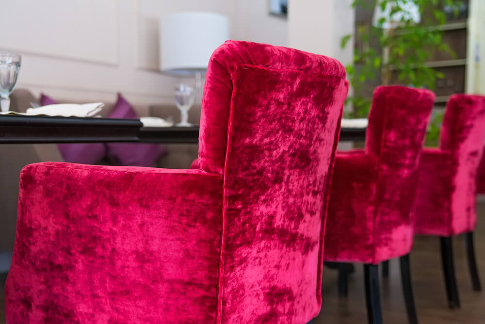 Sillas tapizadas en terciopelo rojo.