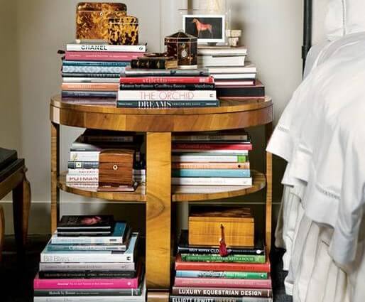 Mesilla con libros apilados.