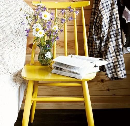 Silla pintada en amarillo como mesilla.