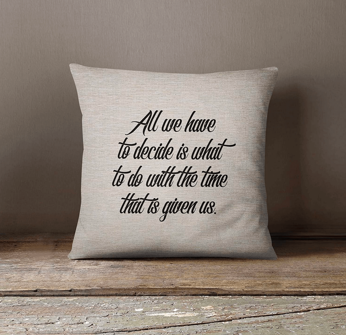 A gray throw pillow with the phrase "All we have to decide is what to do with the time that is given us" in black letters.