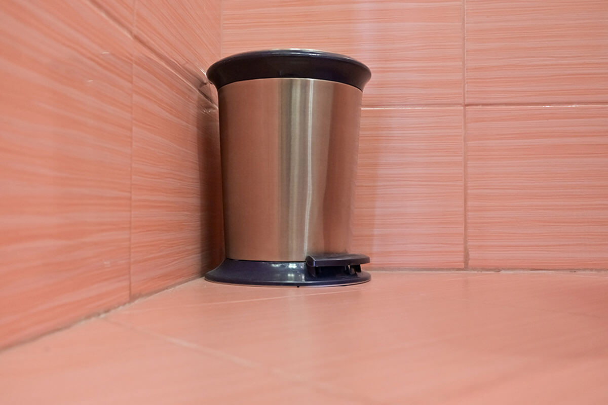 Eliminating bad smell from the bathroom includes keeping the trash can clean.